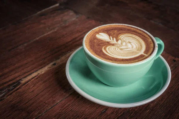 En kopp kaffe med latte konst ovanpå — Stockfoto