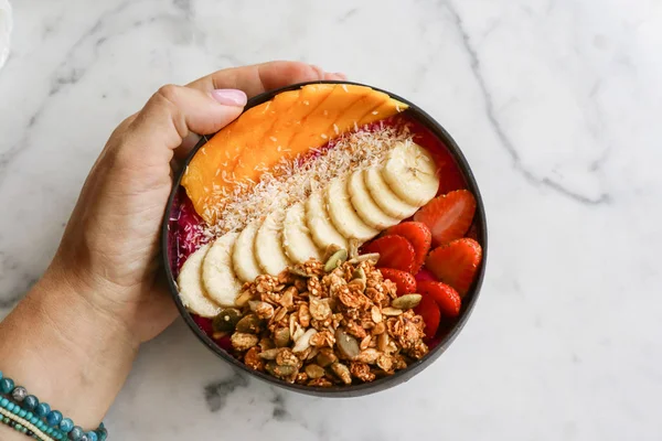 Smoothie bowl with strawberry, dragon fruit, mango and granola