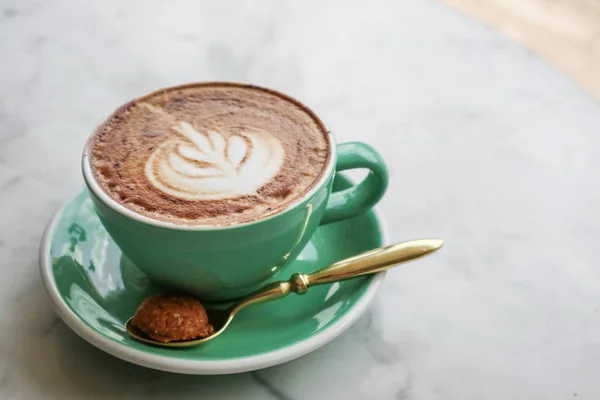 Une tasse de café avec latte art sur le dessus — Photo