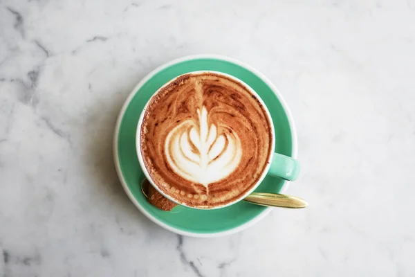 Une tasse de café avec latte art sur le dessus — Photo