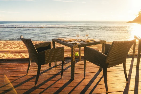 Mesa de comedor y dos sillas en la cubierta junto al mar en la noche su — Foto de Stock