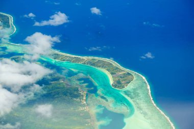 Bulutlar, resif ve lagün adanın havadan görünümü. Ada n