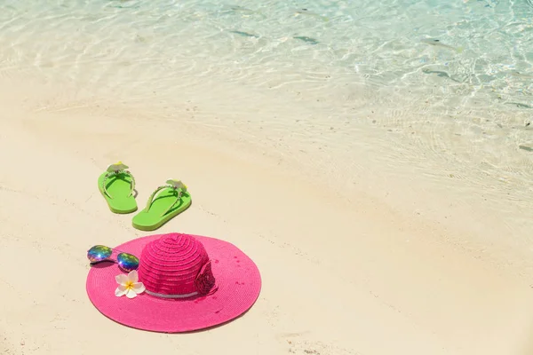 Sombrero de playa rosa con flores, gafas de sol y zapatillas verdes en el —  Fotos de Stock