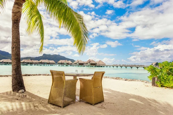 Deux chaises et table sur une plage de sable avec vue sur le lagon a — Photo