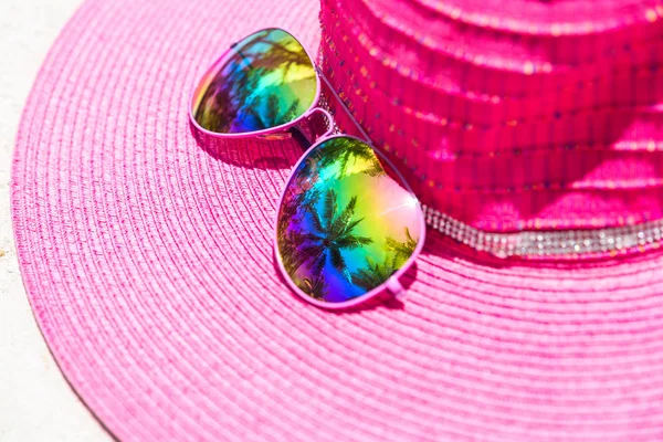 Sombrero de verano rosa y gafas de sol de colores con reflectio palmera — Foto de Stock