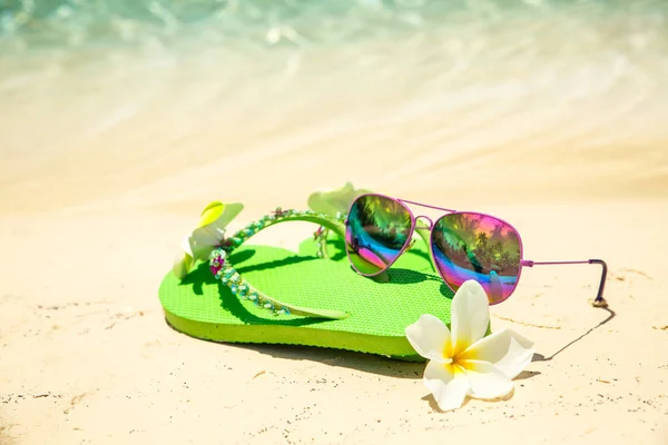Concepto de vacaciones tropicalesChanclas verdes, flor de frangipani —  Fotos de Stock