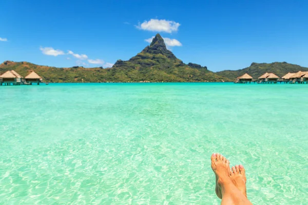 Vrouwelijke gekruiste benen over tropische blauwe lagune en mount Otemanu, — Stockfoto