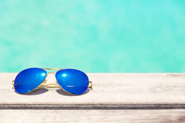 木のデッキの上に横たわる青いサングラス — ストック写真