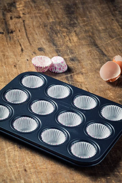 Vassoio vuoto in metallo nero con forme di cupcake di carta pronto per essere fil — Foto Stock