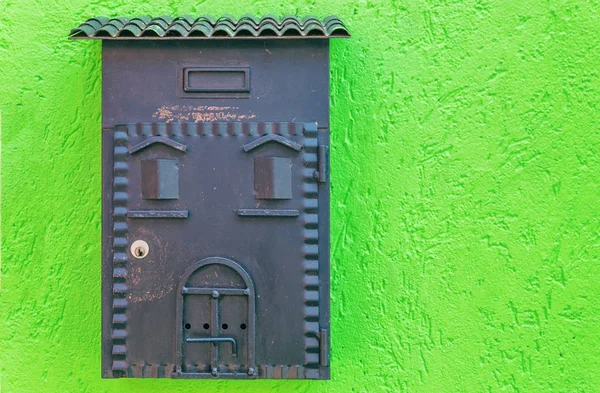 Vintage metal post box on green wall of Burano island street, It