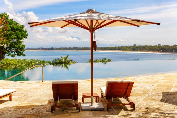 Příjemné tropické bazénu s lehátky a slunečníkem — Stock fotografie