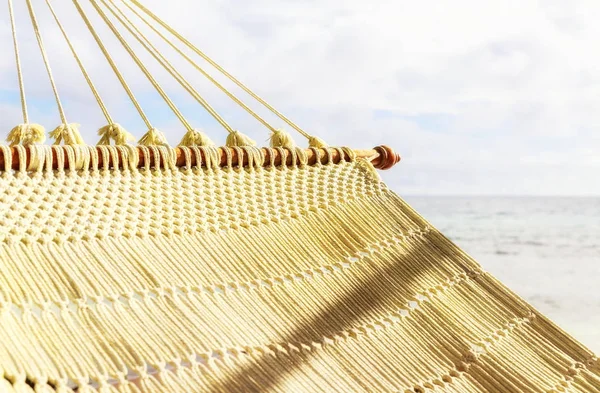 Close up van houten mesh hangmat op het tropische strand aan zee — Stockfoto