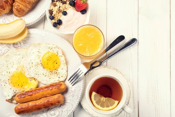 Desayuno con huevos, salchichas, zumo de naranja y f — Foto de Stock