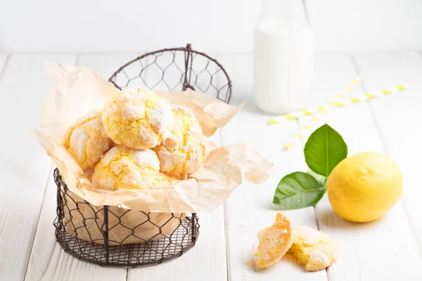 Galletas de limón agrietadas en pequeña cesta de metal en respaldo de mesa blanca — Foto de Stock