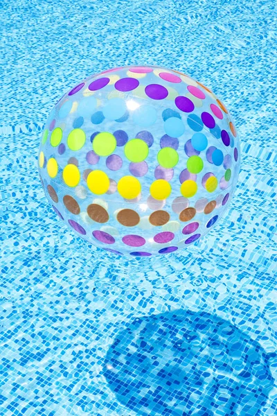 青いスイミングプールの水に浮かぶインフレータブルカラフルなボール 垂直組成 — ストック写真