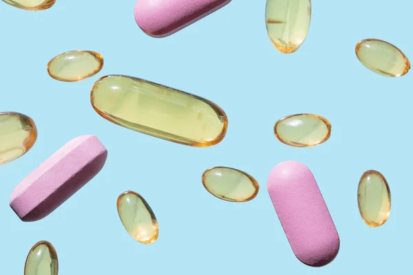 Capsule Mediche Gialle Trasparenti Pillole Rosa Sfondo Azzurro — Foto Stock