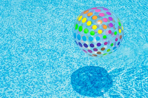 コピースペースと青いスイミングプールの水に浮かぶインフレータブルカラフルなボール — ストック写真