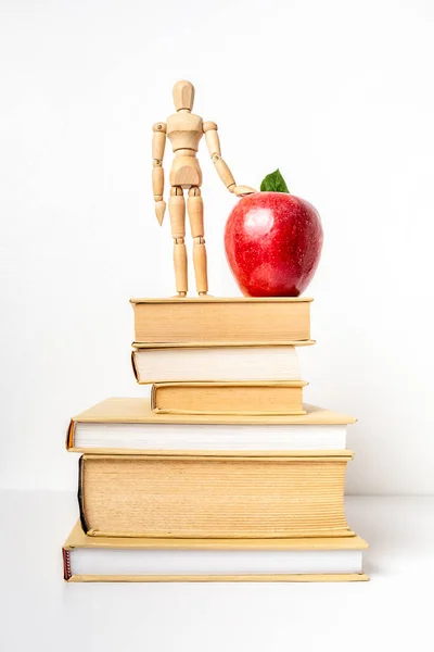 Stuck Books Red Apple Wooden Mannequin Isolated White Background Vertical — Stock Photo, Image