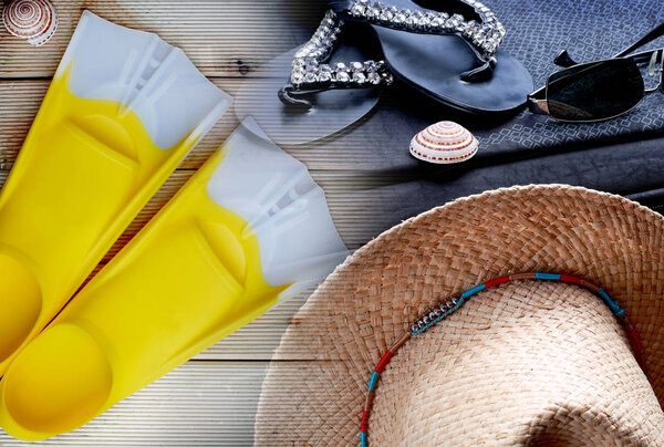 a suitcase on the slippers, sunglasses, hats and mussels on background