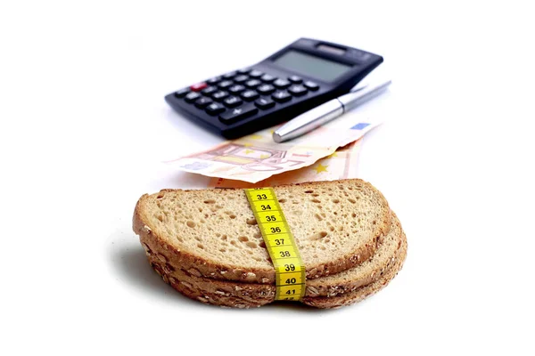 Moeda de euro com calculadora financeira e fatia marrom de pães — Fotografia de Stock