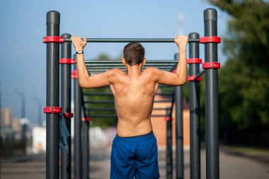 Genç adam kendini oyun parkının yatay çubuğuna çekti..