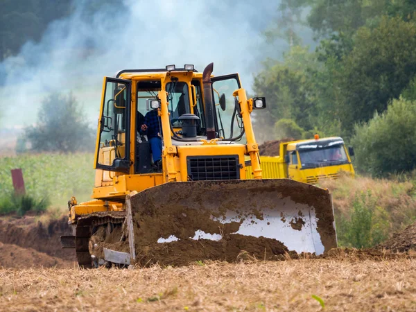 Werknemer bulldozer werk op het gebied — Stockfoto