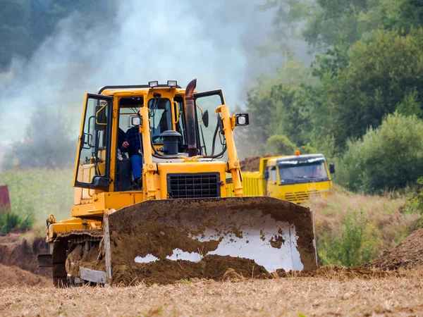 Werknemer bulldozer werk op het gebied — Stockfoto