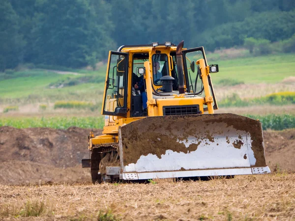 Werknemer bulldozer werk op het gebied — Stockfoto