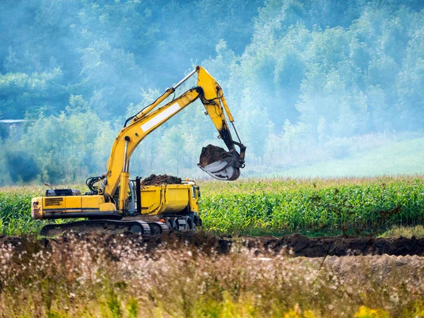 Graafmachine werkt op het gebied — Stockfoto