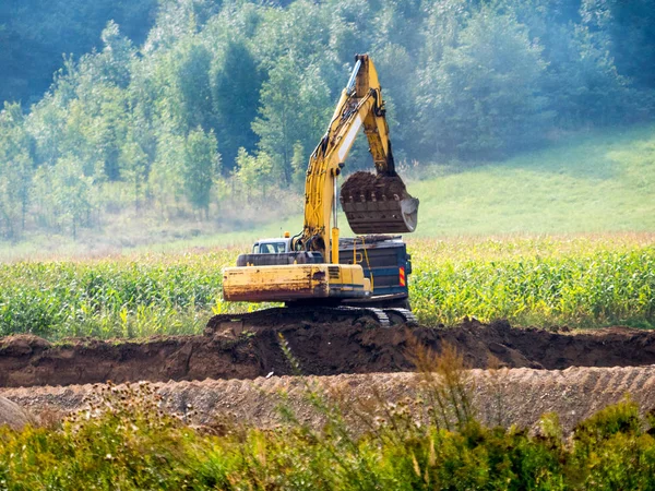 Grävmaskin fungerar i fältet — Stockfoto