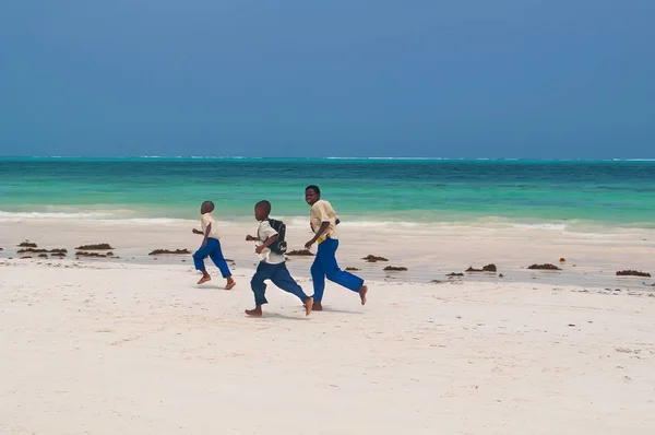 Tre Zanzibar pojkar kör längs vita sandstranden — Stockfoto