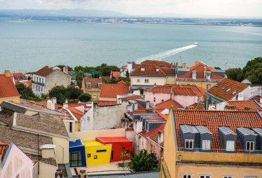 Lizbon ve river Tagus, ilçe mesafe yelken bir motorlu tekne renkli evlerin bir parçası üzerinde güzel bir güneşli üstten görünüm
