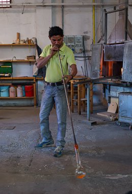 Murano, İtalya - 09 Ekim, 2013: çırak bir cam heykel bir gösterisi sırasında üfleme ünlü Murano cam fabrikasında bir ustanın
