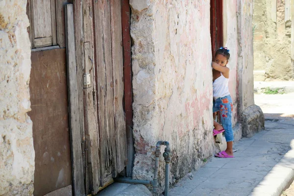 Küba, Havana - 07 Nisan, 2016: küçük bir kız nerede onun anne yapıyor kendini güzel eski püskü mahallede bir tırnak salonu dışında merakım yüzünden ile annesi için bekliyor 