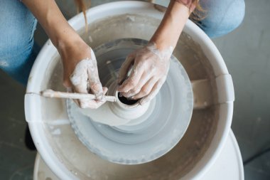 Potter's tekerlek üzerinde el işi, el ev ve satış için çeşitli öğeleri çamurdan mağazada yapacaklar ve sergisinde, seramik öğeleri el yapılır, kil kütük bir seramik tabak olur