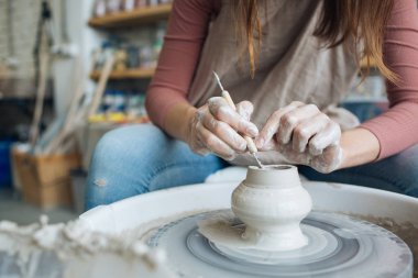 Potter's tekerlek üzerinde el işi, el ev ve satış için çeşitli öğeleri çamurdan mağazada yapacaklar ve sergisinde, seramik öğeleri el yapılır, kil kütük bir seramik tabak olur
