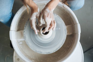 Potter's tekerlek üzerinde el işi, el ev ve satış için çeşitli öğeleri çamurdan mağazada yapacaklar ve sergisinde, seramik öğeleri el yapılır, kil kütük bir seramik tabak olur