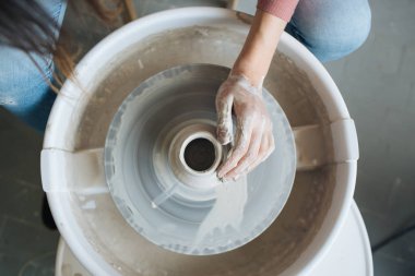 Potter's tekerlek üzerinde el işi, el ev ve satış için çeşitli öğeleri çamurdan mağazada yapacaklar ve sergisinde, seramik öğeleri el yapılır, kil kütük bir seramik tabak olur