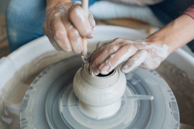 Potter's tekerlek üzerinde el işi, el ev ve satış için çeşitli öğeleri çamurdan mağazada yapacaklar ve sergisinde, seramik öğeleri el yapılır, kil kütük bir seramik tabak olur