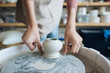 Potter's tekerlek üzerinde el işi, el ev ve satış için çeşitli öğeleri çamurdan mağazada yapacaklar ve sergisinde, seramik öğeleri el yapılır, kil kütük bir seramik tabak olur
