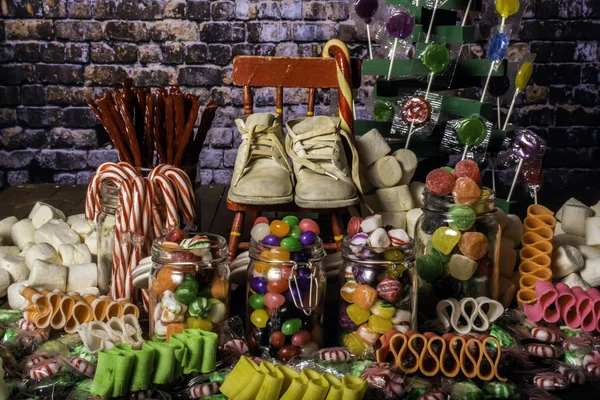 Zapatos Bebé Reales Una Pequeña Mecedora Roja Rodeada Dulces Coloridos — Foto de Stock