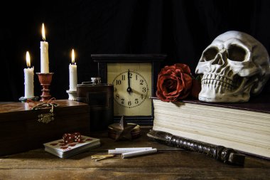 Kötü alışkanlıklarla ilişkili nesnelerin yaşamı iskambil kağıtlarıyla oynanan sigaralar yanan mumlarla şişe siyah kriko ve büyük İncil 'de kırmızı gül olan insan kafatası.