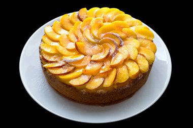 Şeftali pasta beyaz plaka ve ayrı tut siyah arka plan üzerinde.