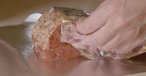 在食物中包裹着一块新鲜的猪肉 用调料腌制并撒满大蒜 准备在烤箱中烘烤 看一个人的手 — 图库视频影像