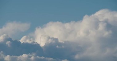 Mavi gökyüzünde kümülüs bulutlarının hareket etmesi zaman aşımına uğrar.