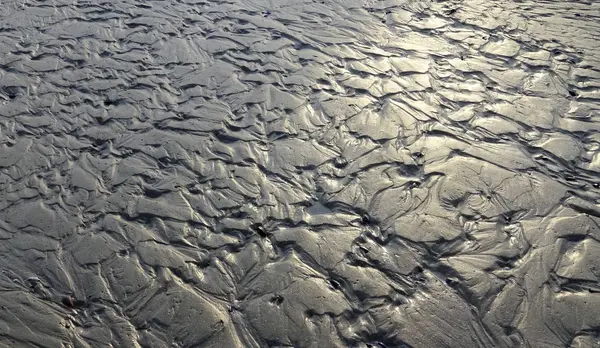 Малюнки на грязьовому дні поля відпливу, відображення — стокове фото