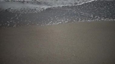 Kumlu sahilde haddeleme deniz, dalgalar ve beyaz köpük, güçlü bir fırtına