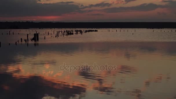 Rød solnedgang over Hadzhibey-elvemunningen, refleksjon i skyenes vann – stockvideo