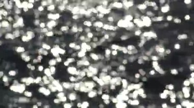 Bokeh güneş parlamayı güneşli yaz günü, bulanık arka plan su su yüzeyinden yansıtılır. Güneş parlamayı su. 