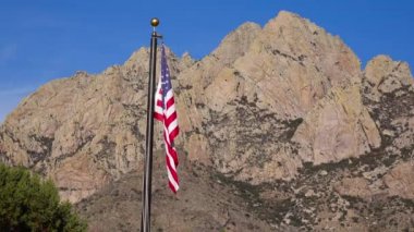 Arizona 'daki ulusal parkın ziyaretçi merkezi yakınlarındaki dağ oluşumlarının arka planında Amerikan bayrağı var.